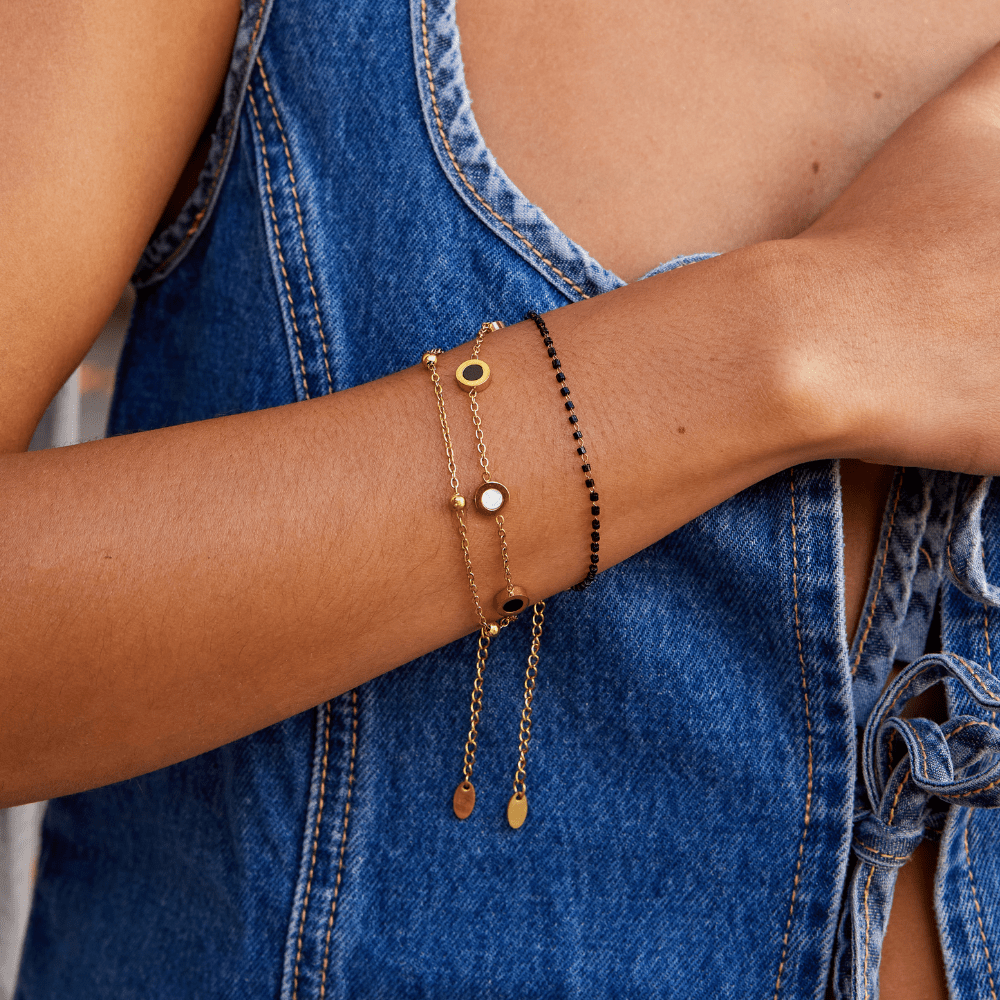 Armband mit Onyx- und Weißsteinanhängern in Gold