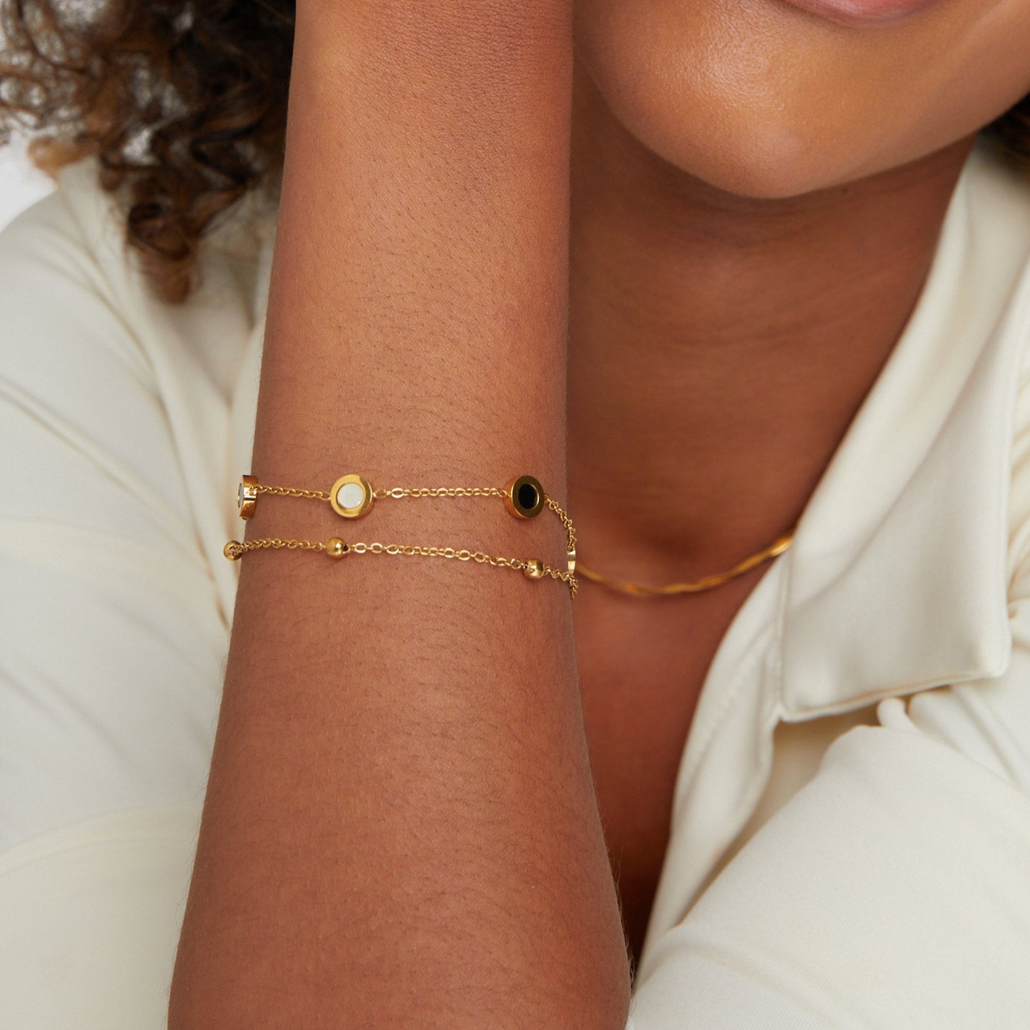 Armband mit Onyx- und Weißsteinanhängern in Gold
