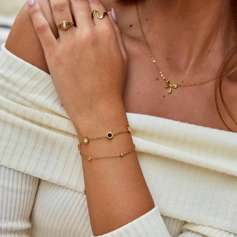 Armband mit Onyx- und Weißsteinanhängern in Gold