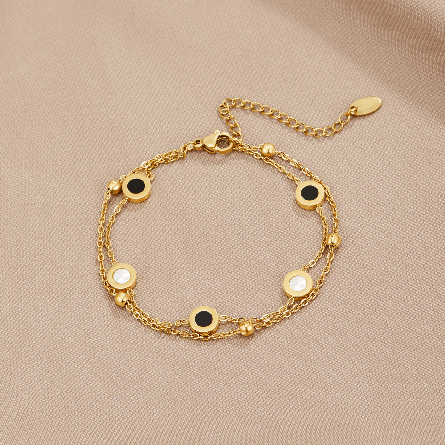 Armband mit Onyx- und Weißsteinanhängern in Gold