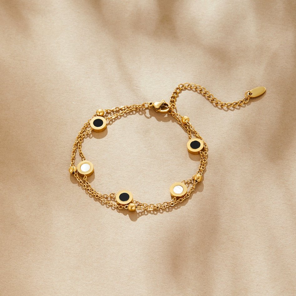 Armband mit Onyx- und Weißsteinanhängern in Gold