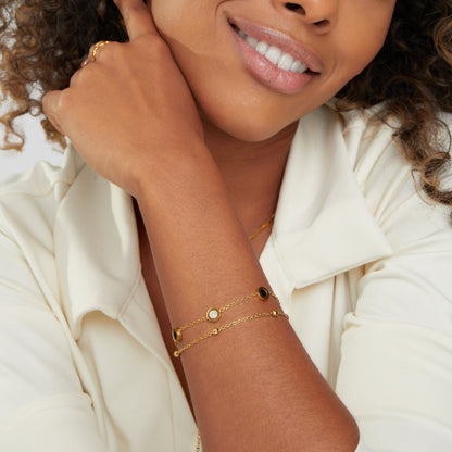 Armband mit Onyx- und Weißsteinanhängern in Gold